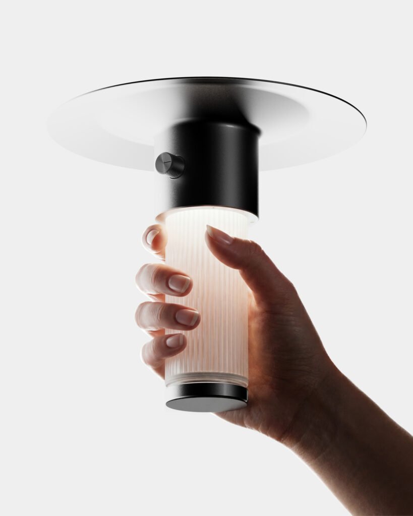 edwin est une lampe rechargeable dessinée par alix videlier design studio. Une main tient la lampe par le tube de verre.