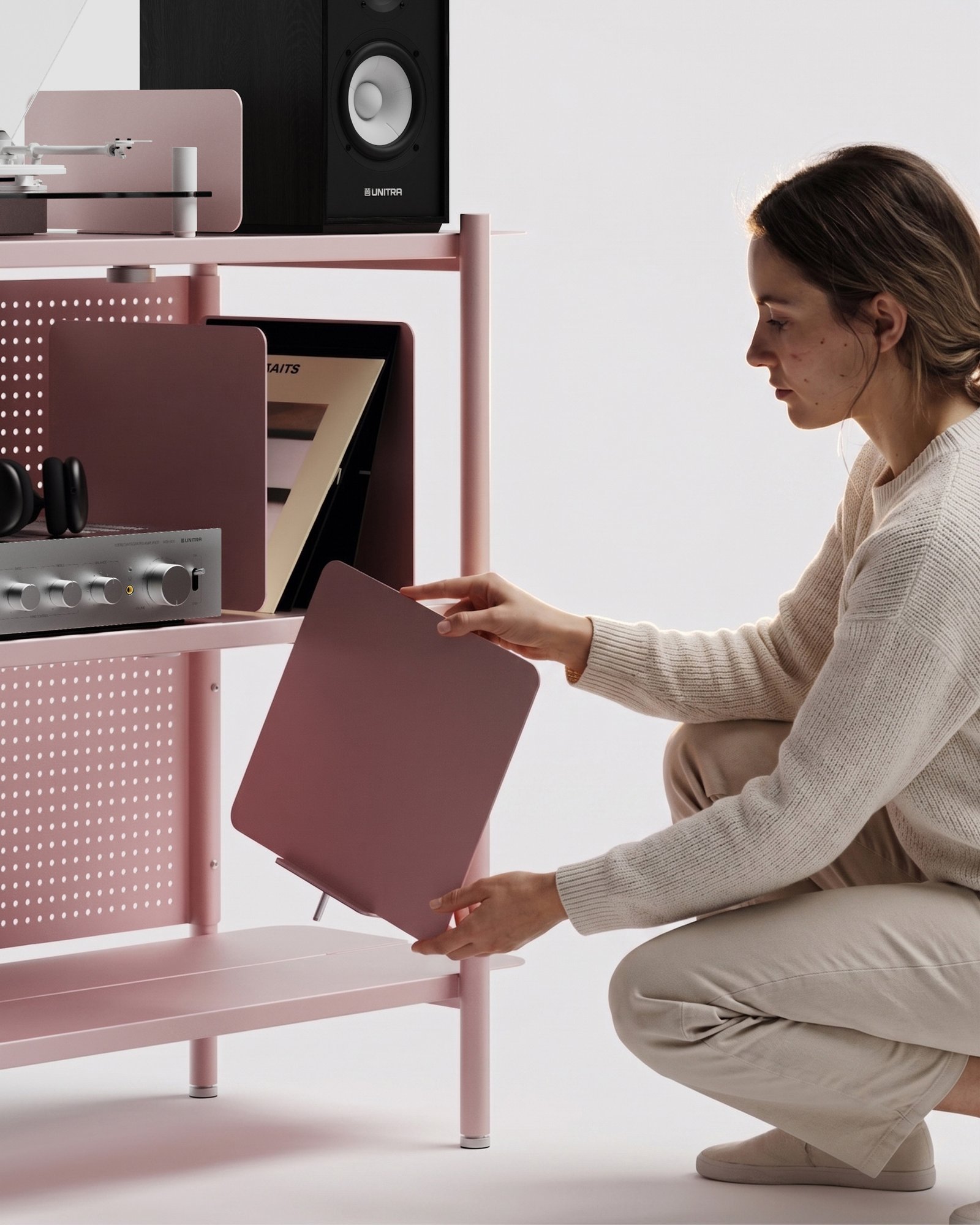 assemblage du meuble vinyle modulaire Lara par Alix Videlier. Une personne ajuste les parois en fonction de ses besoins.